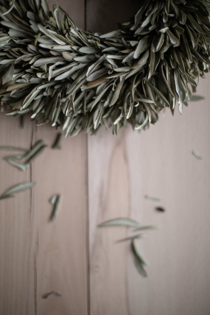 A detailed shot of an olive leaf wreath resting on a wooden surface, perfect for decor ideas.